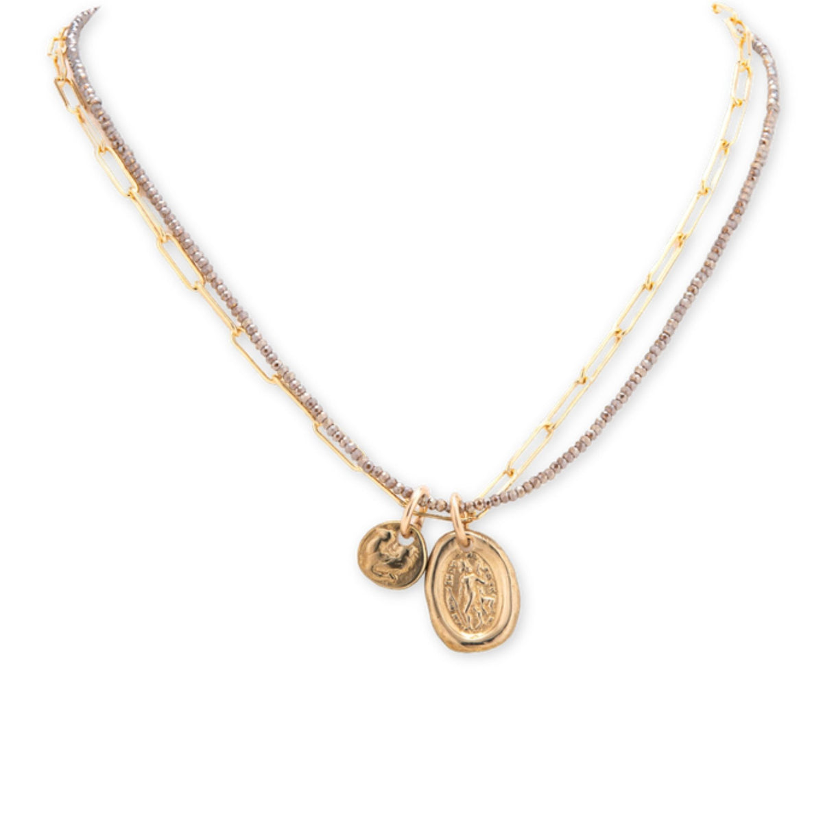 Layered necklace with pyrite beads and a gold paperclip chain holding an oval gold medal and a small disc charm