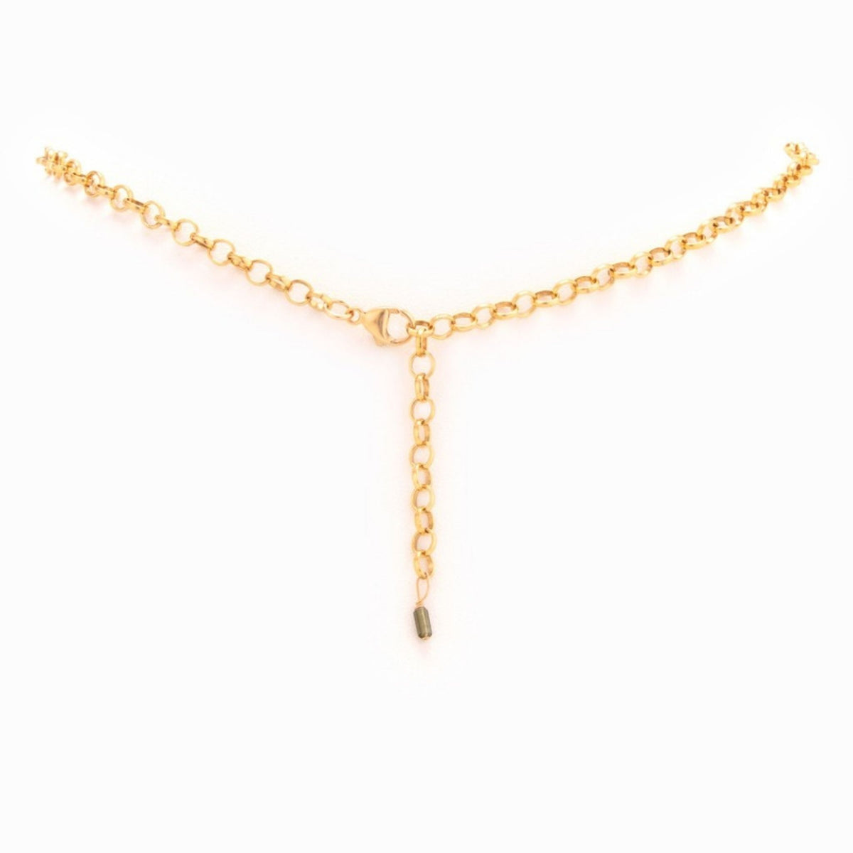 Gold rolo chain necklace laid flat, showing the lobster clasp, extender chain and a small green gem drop