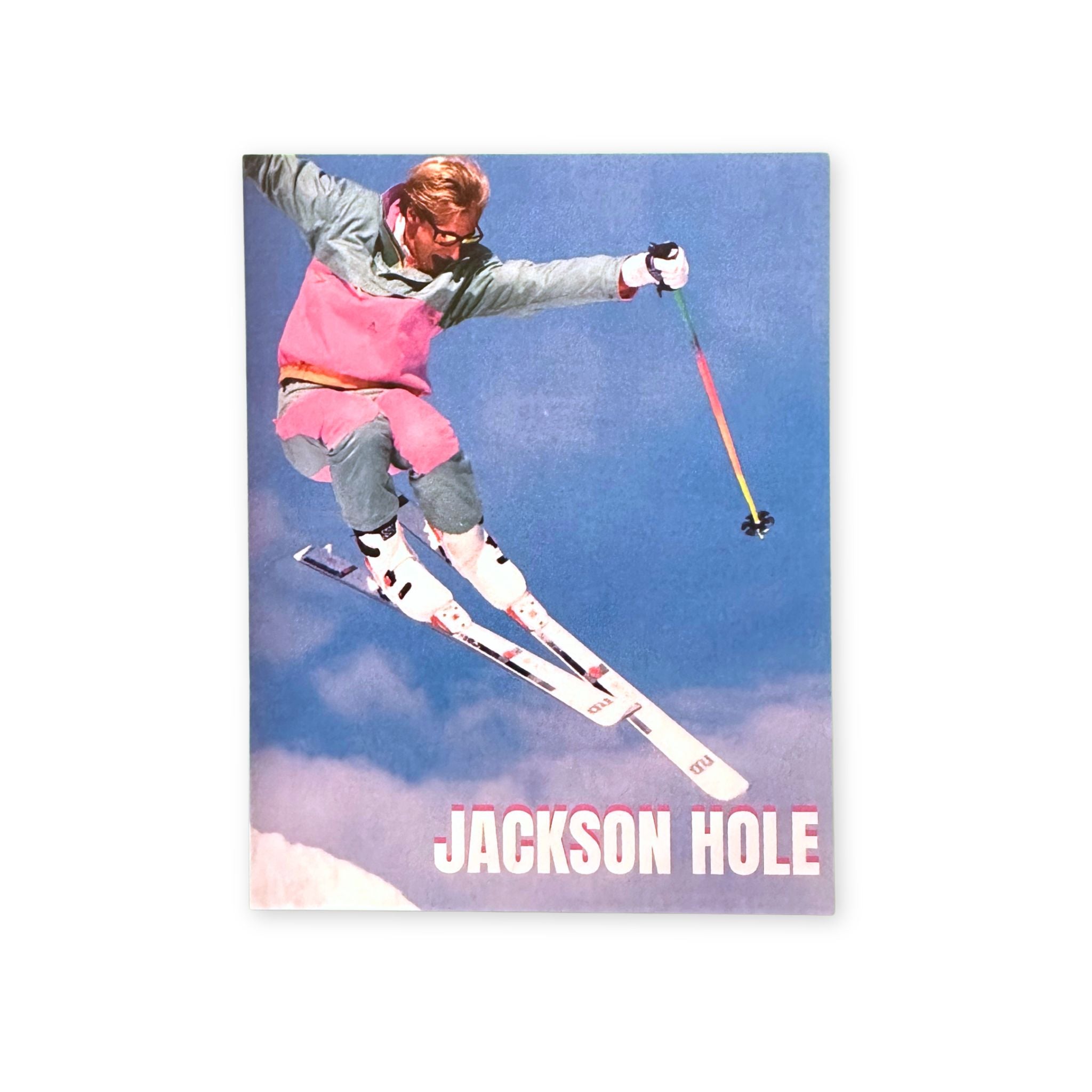 Postcard with a Skiier in mid-air with 'Jackson Hole' text against a blue sky