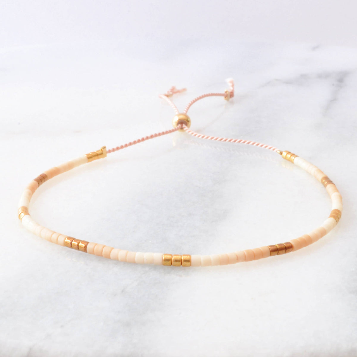 Bracelet with beige and gold beads.