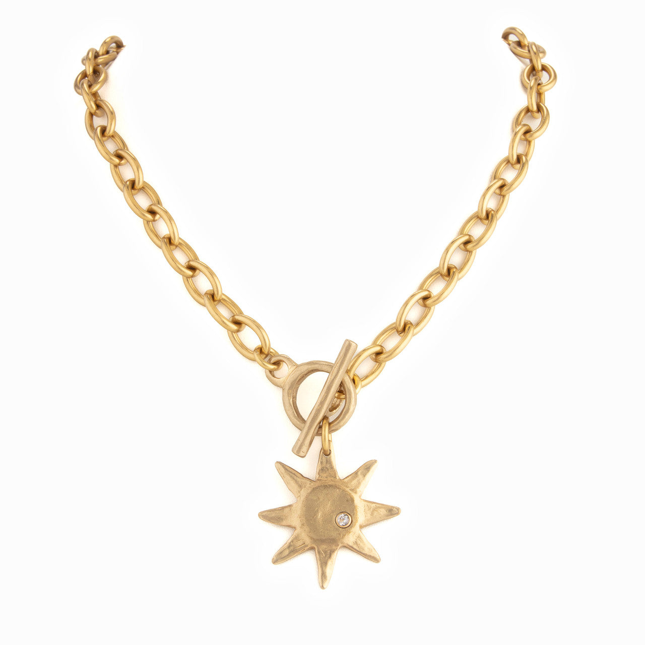 Gold chain necklace with a sun-shaped pendant on a white background