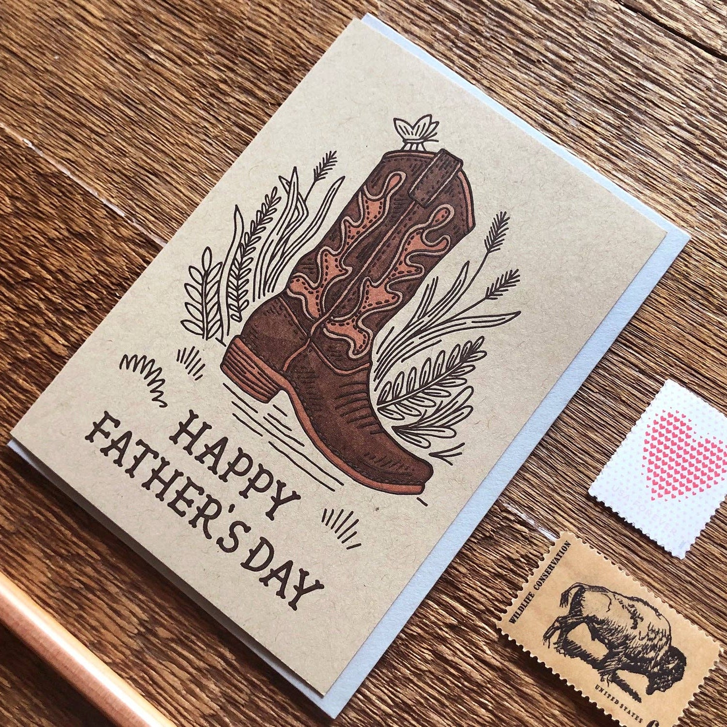 Father's Day card with cowboy boot illustration on a wooden surface
