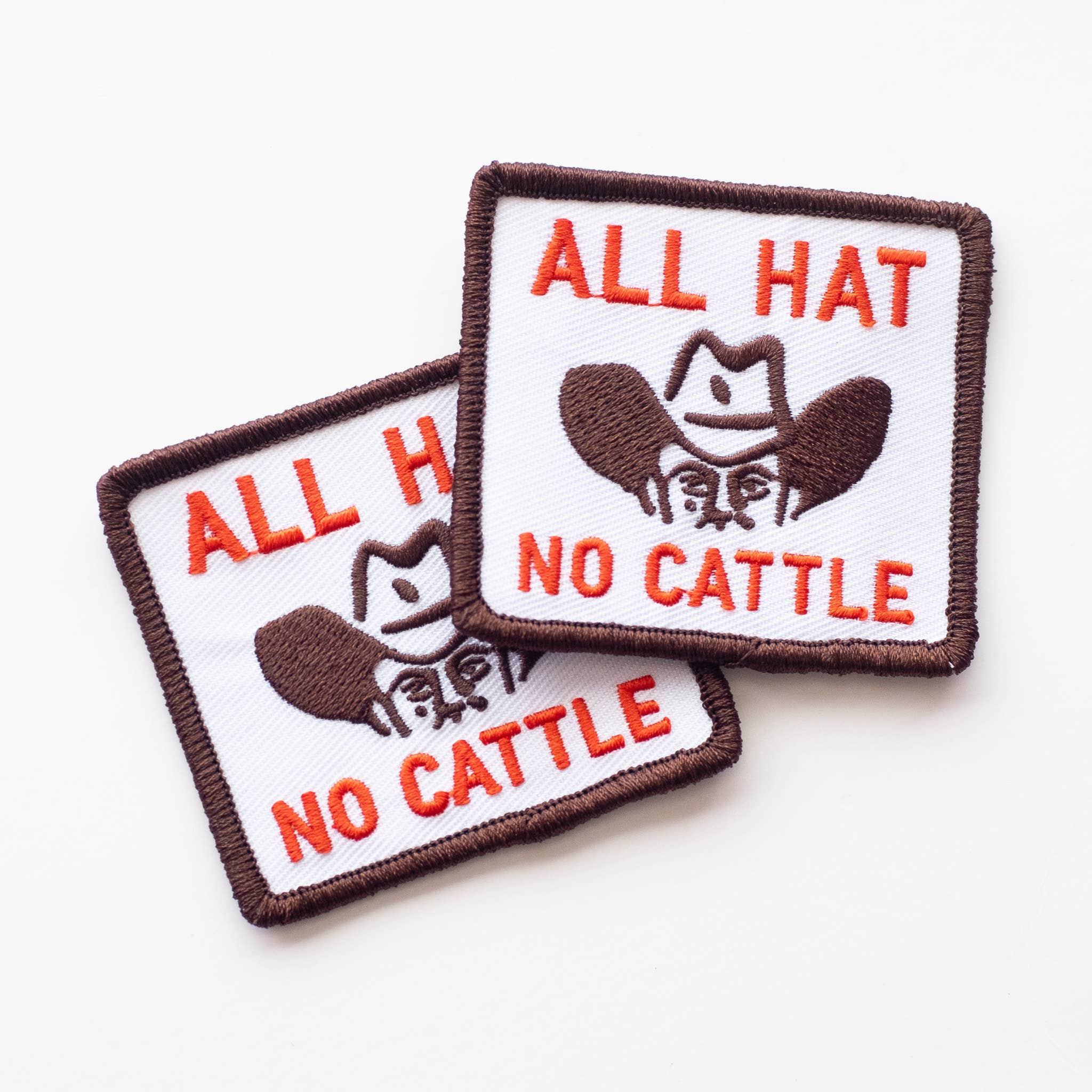 Two patches with 'All Hat No Cattle' text and a cowboy hat graphic on a white background.