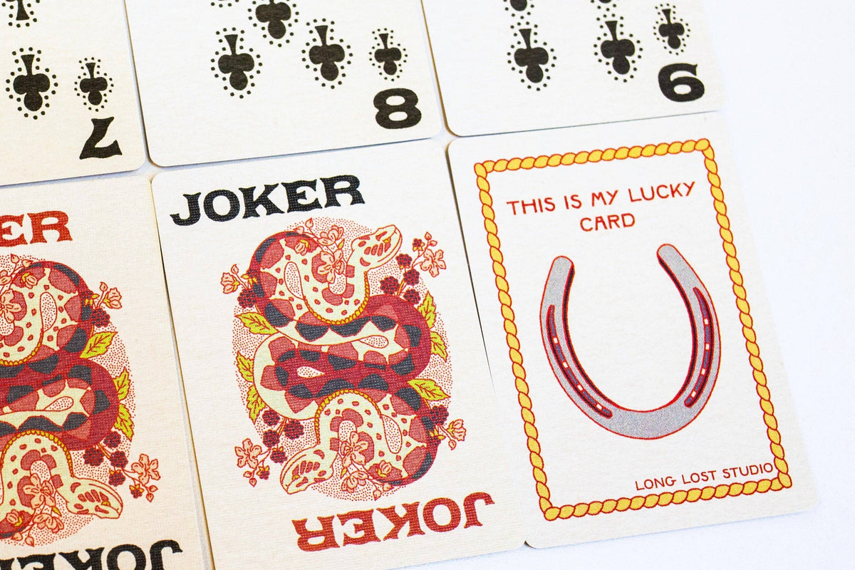 A close-up of playing cards showing Joker cards and a lucky card with a horseshoe illustration.