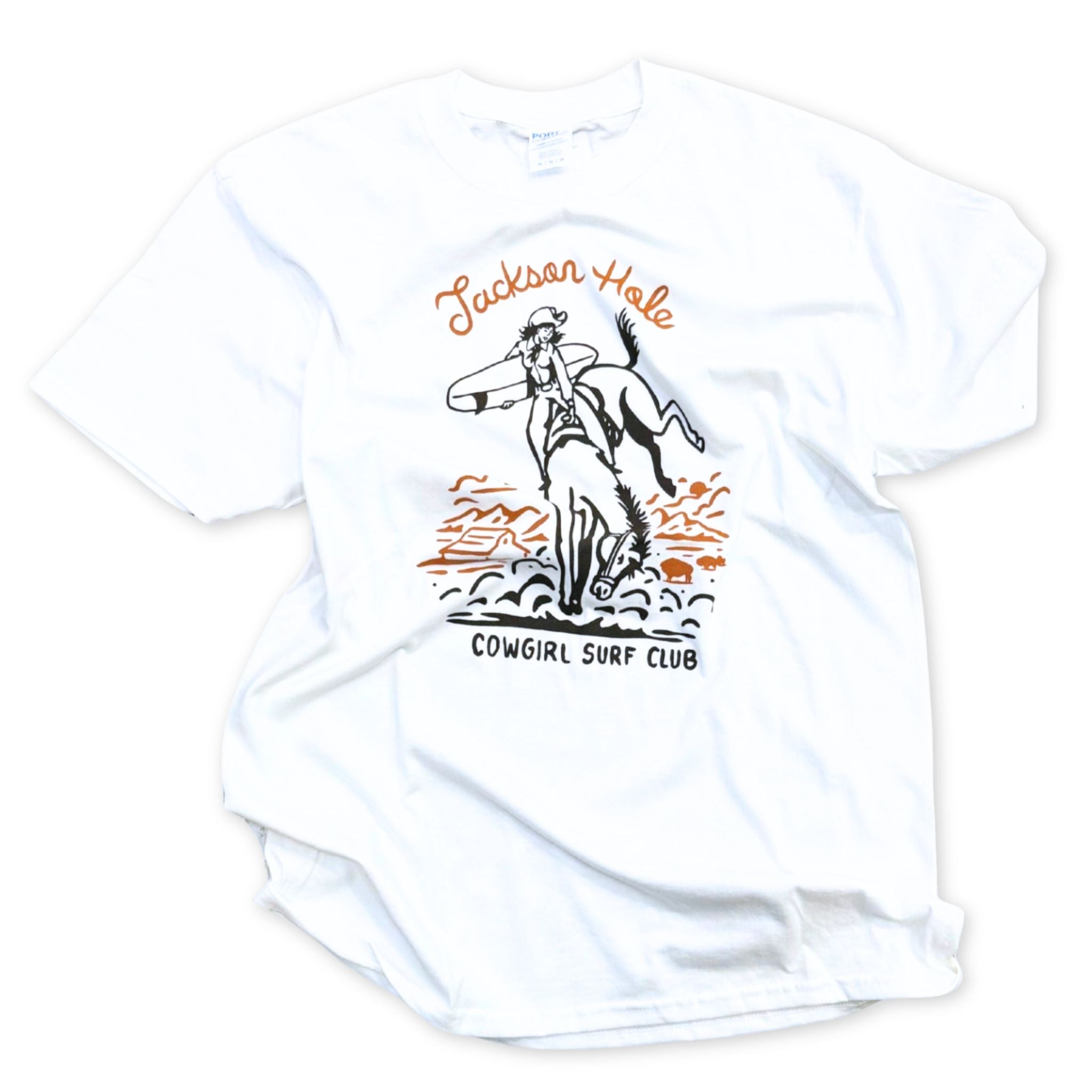 White t-shirt with a graphic of a cowgirl surfing and text 'Jackson Hole Cowgirl Surf Club' on a white background.
