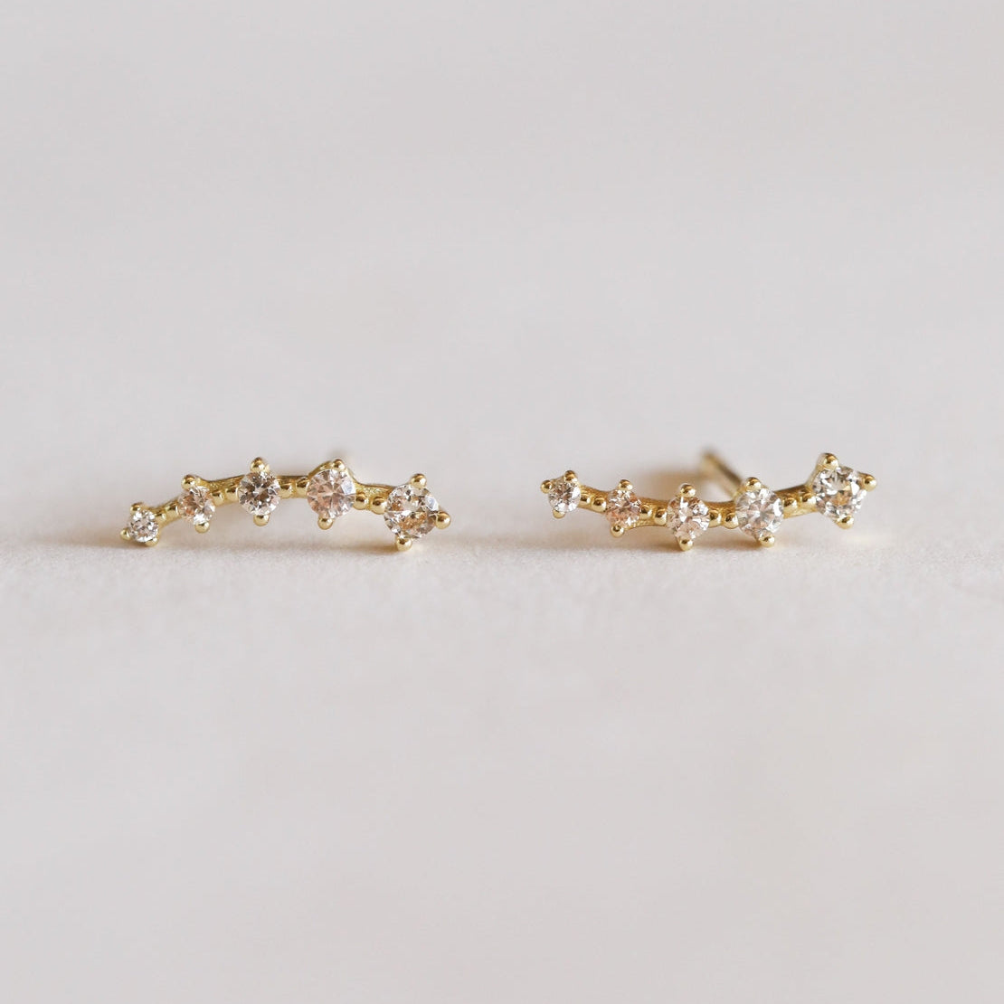 Pair of champagne colored crawler studs.