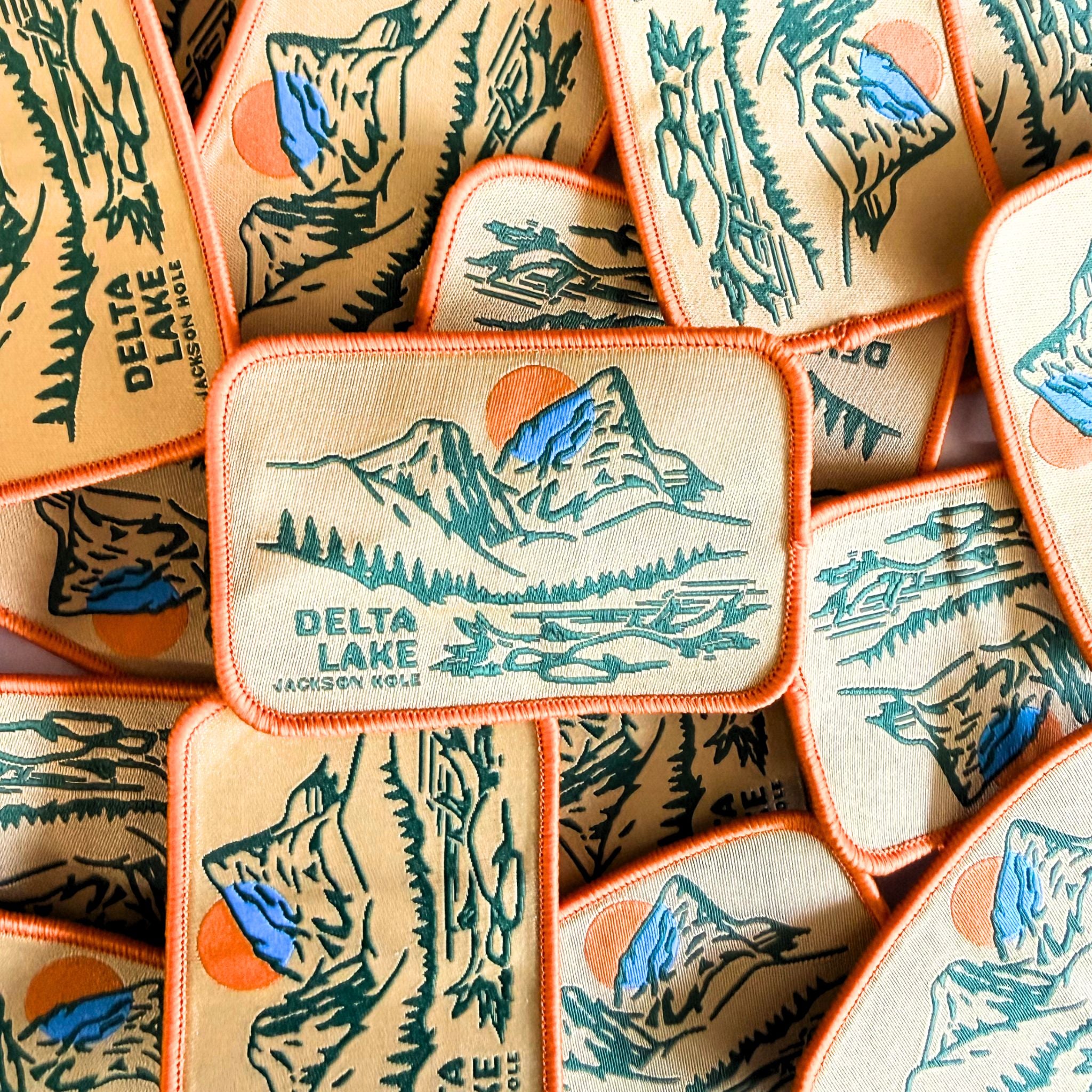 A patch showing an illustration of Delta Lake, with colors Orange, blue and green.