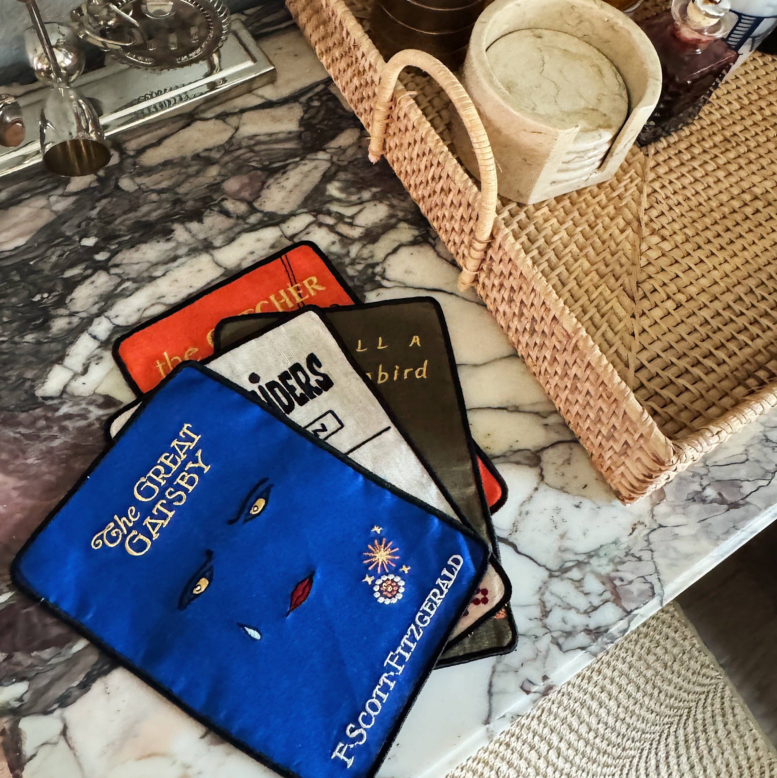 Set of fabric book covers with 'The Great Gatsby' design on a marble surface.