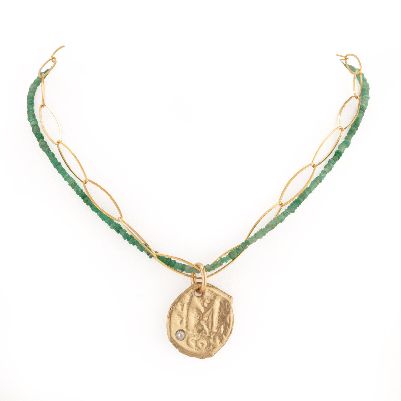 Necklace with green beads and gold pendant on a white background