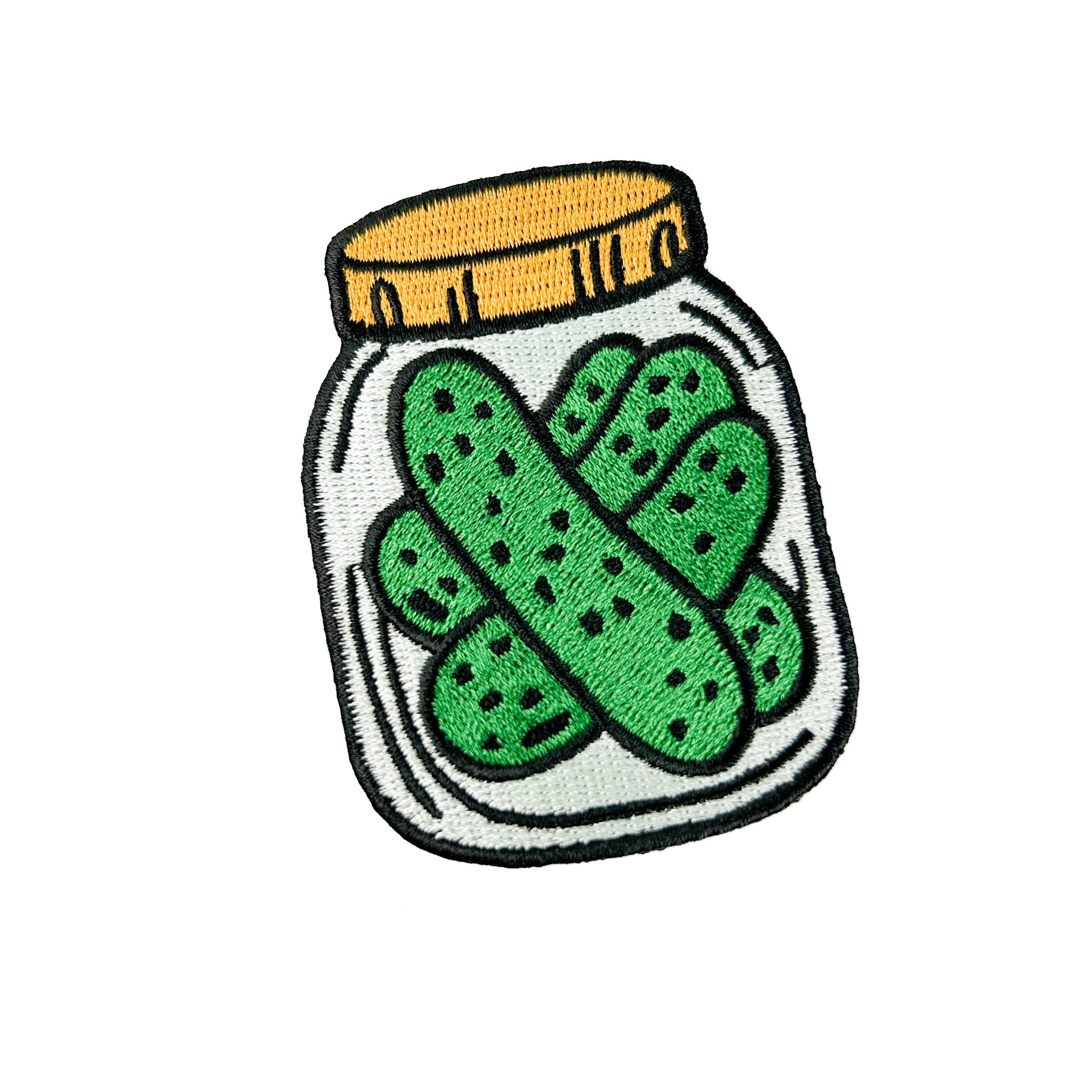 Embroidered iron on patch of a jar with green pickles.