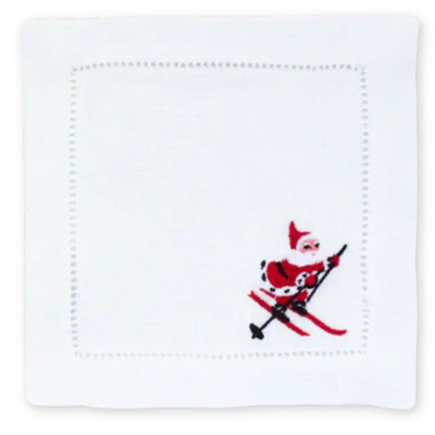 White linen napkins, with an embroidered skiing Santa clause in the right corner