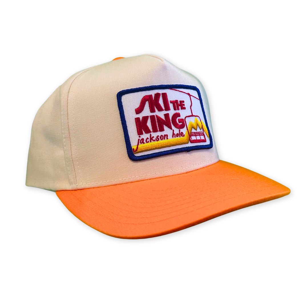 White and Orange two tone trucker hat, with Ski the King Patch