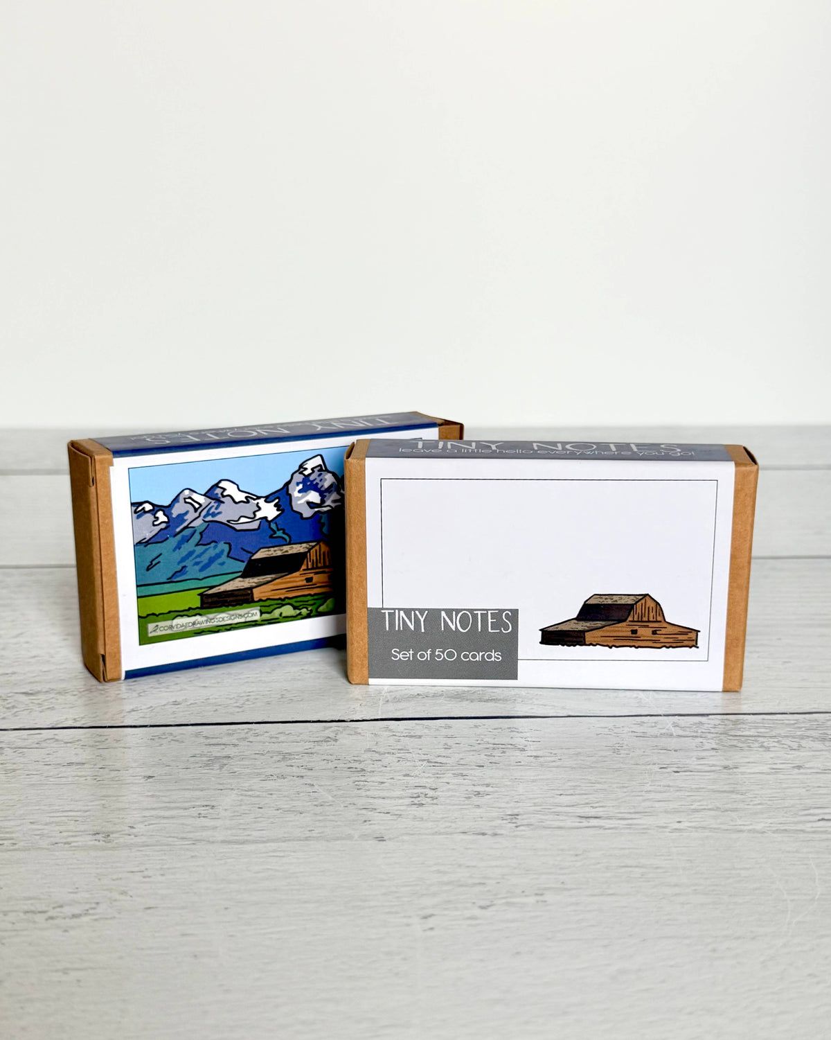 TINY NOTES Set of 50 cards' and shows a small barn illustration; the rear box has a colorful mountain landscape illustration on the front.