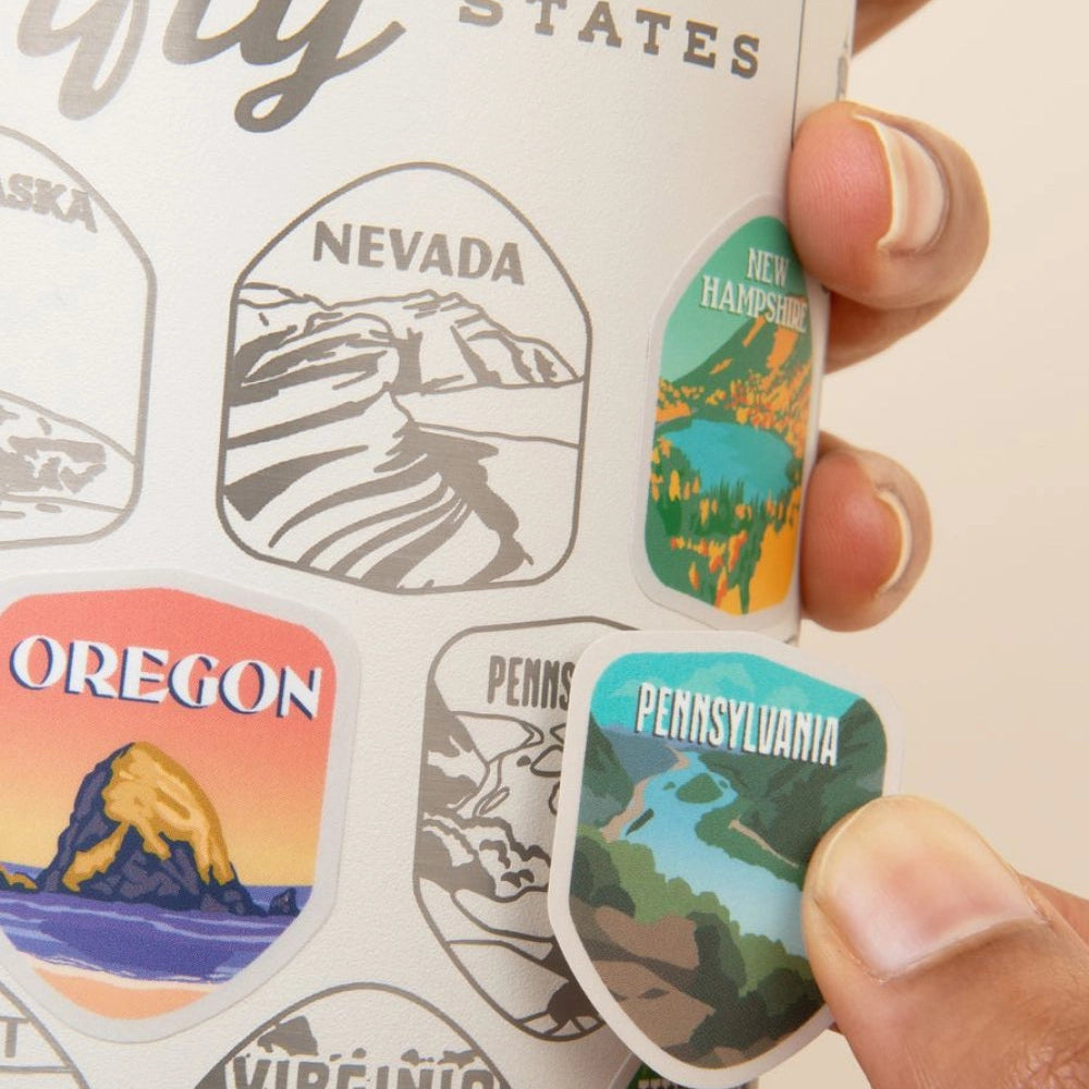 Sticker with state designs held by a hand, featuring Nevada, New Hampshire, Oregon, and Pennsylvania.
