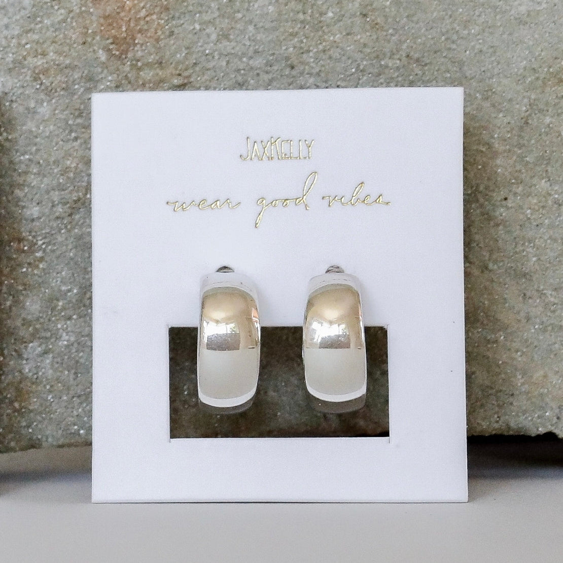 A pair of wide silver stud hoops.