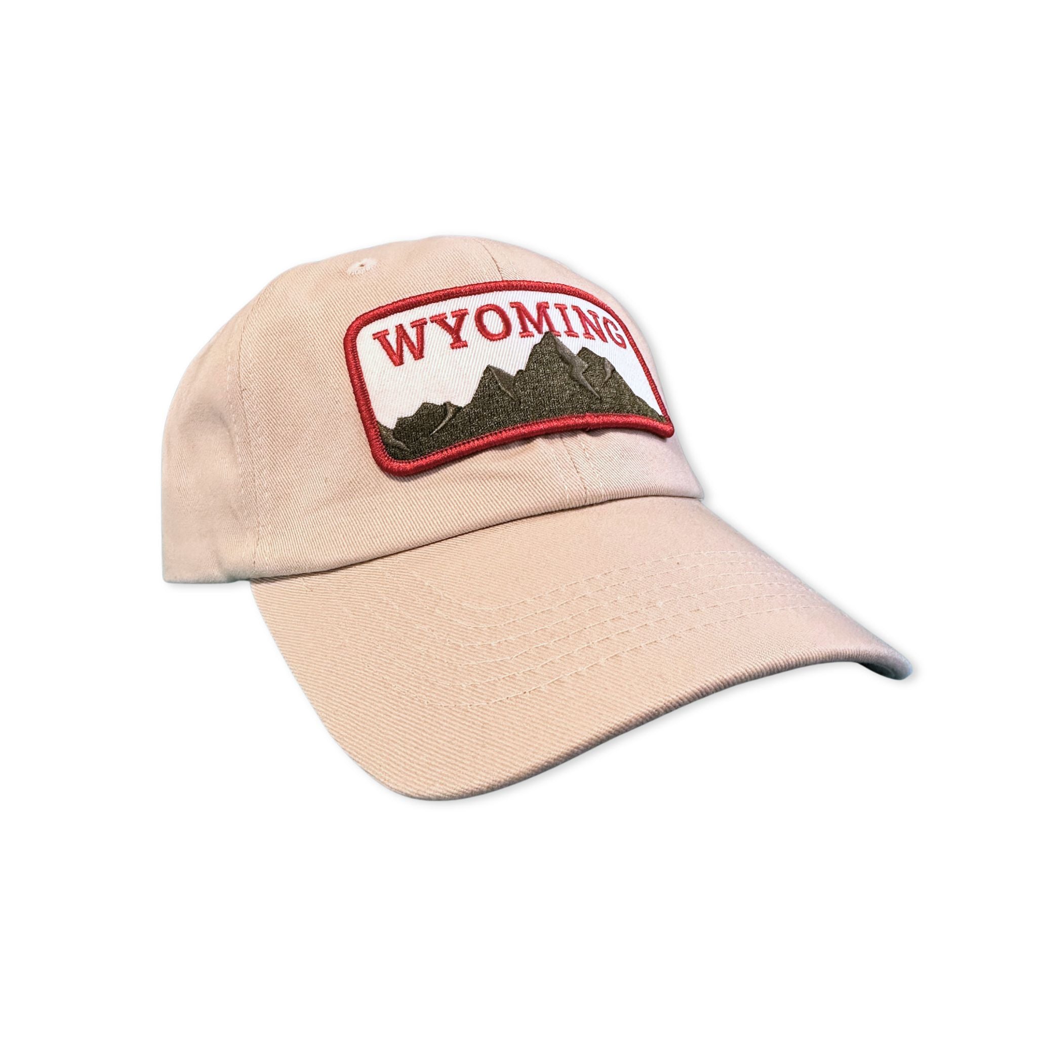 Tan dad hat with a red, green, and white patch of the Wyoming Mountains, with text stating WYOMING.