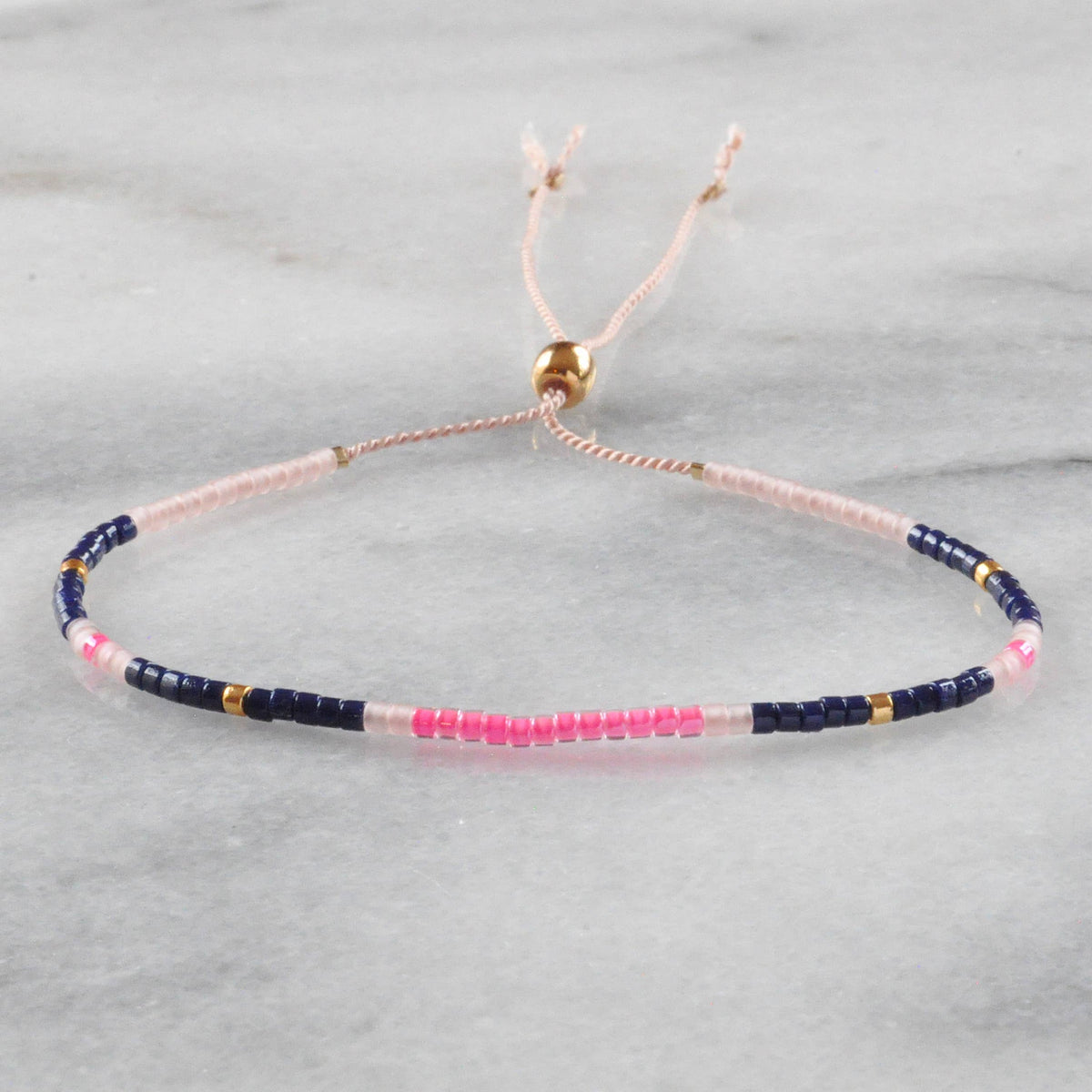 Beaded bracelet with pink, blue, and gold beads.