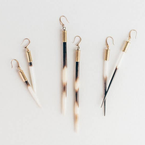 Set of five gold and black earrings on a light gray background