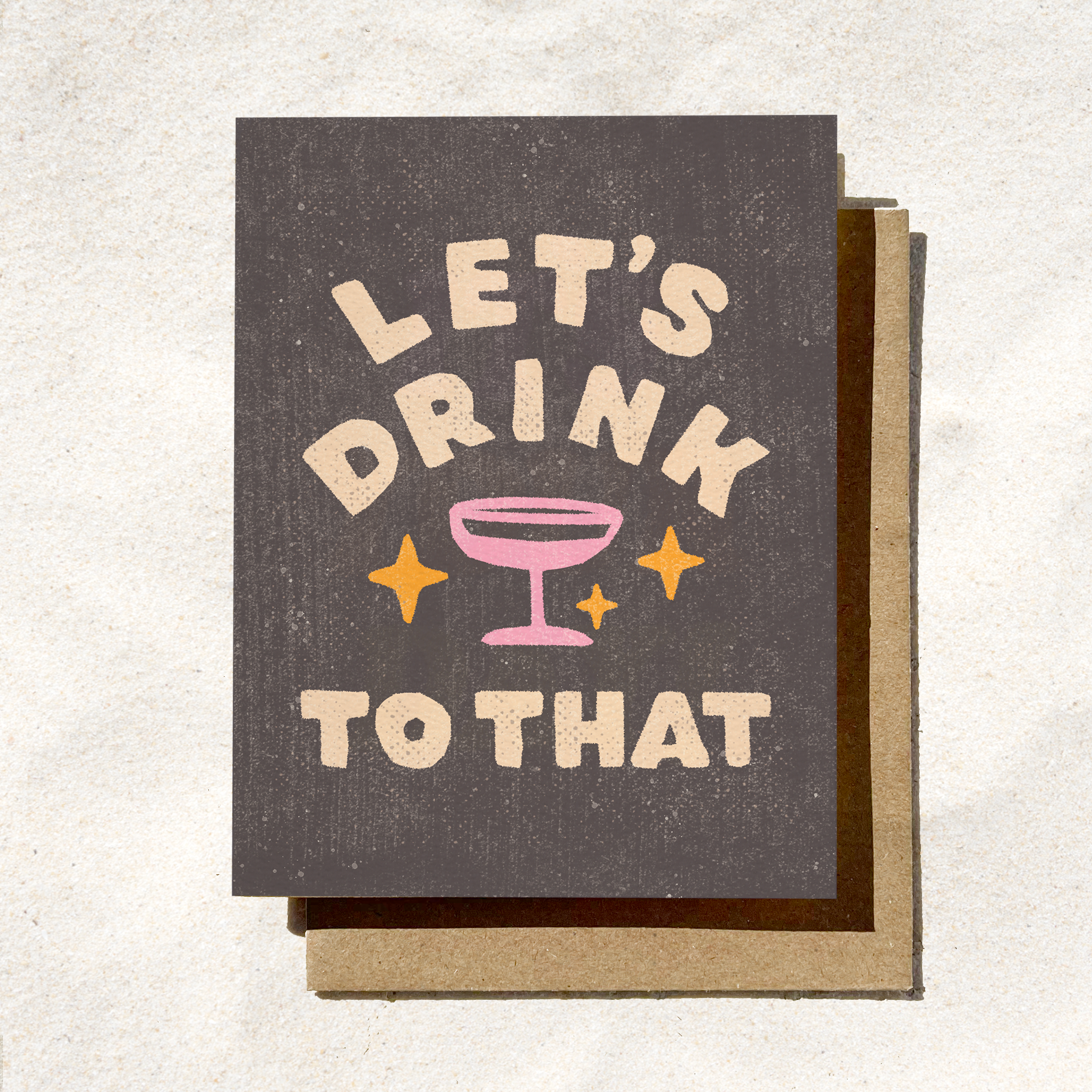 Greeting card with 'Let's Drink to That' text and cocktail illustration on a textured background