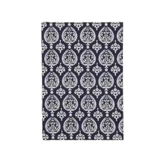 A navy-colored, hardbound journal with a traditional patterned design on the cover, featuring a space for personalization on the front.