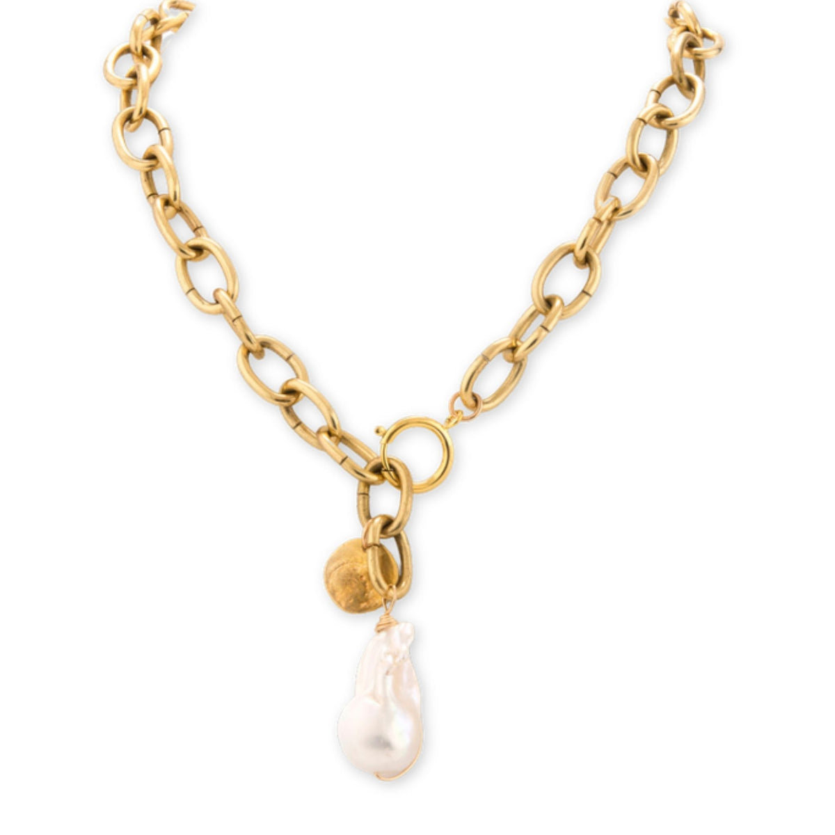 Brass chain necklace with a large baroque pearl drop and a small hammered brass disc charm on a white background