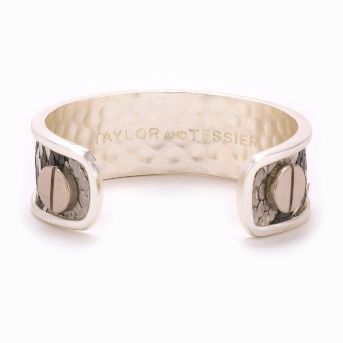 Inside view of a silver cuff with gray snakeskin-textured leather ends and screws over a hammered interior