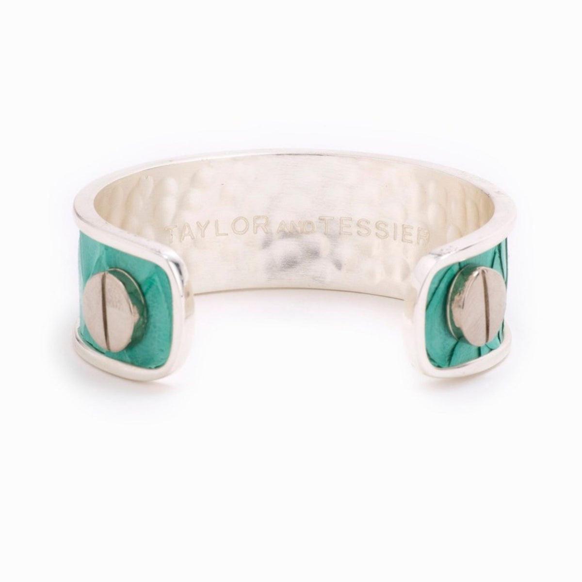 Inside view of a silver cuff with teal green leather panels, silver screws and a hammered inner surface