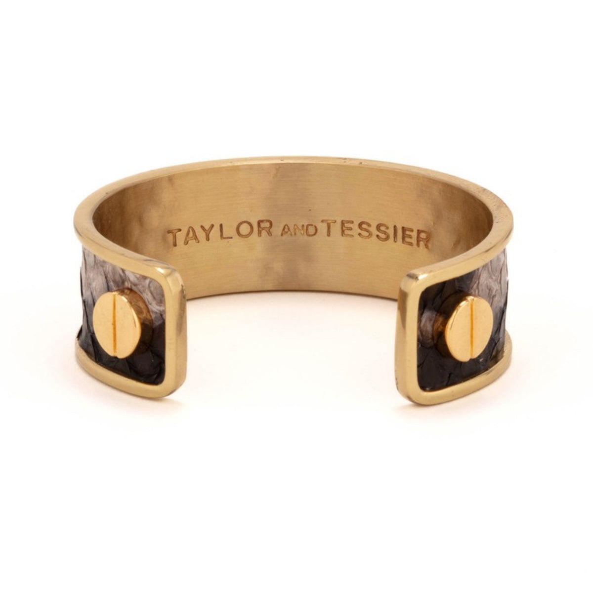 Inside view of a brushed gold cuff with black and gray snake-textured leather ends and gold screws