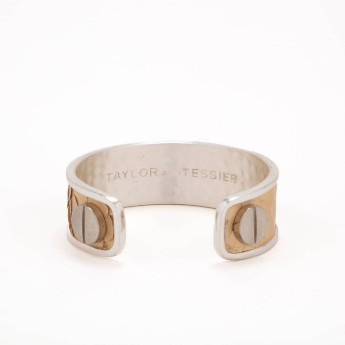 Inside view of a silver cuff with tan and gold python leather ends, brushed screws and engraved logo