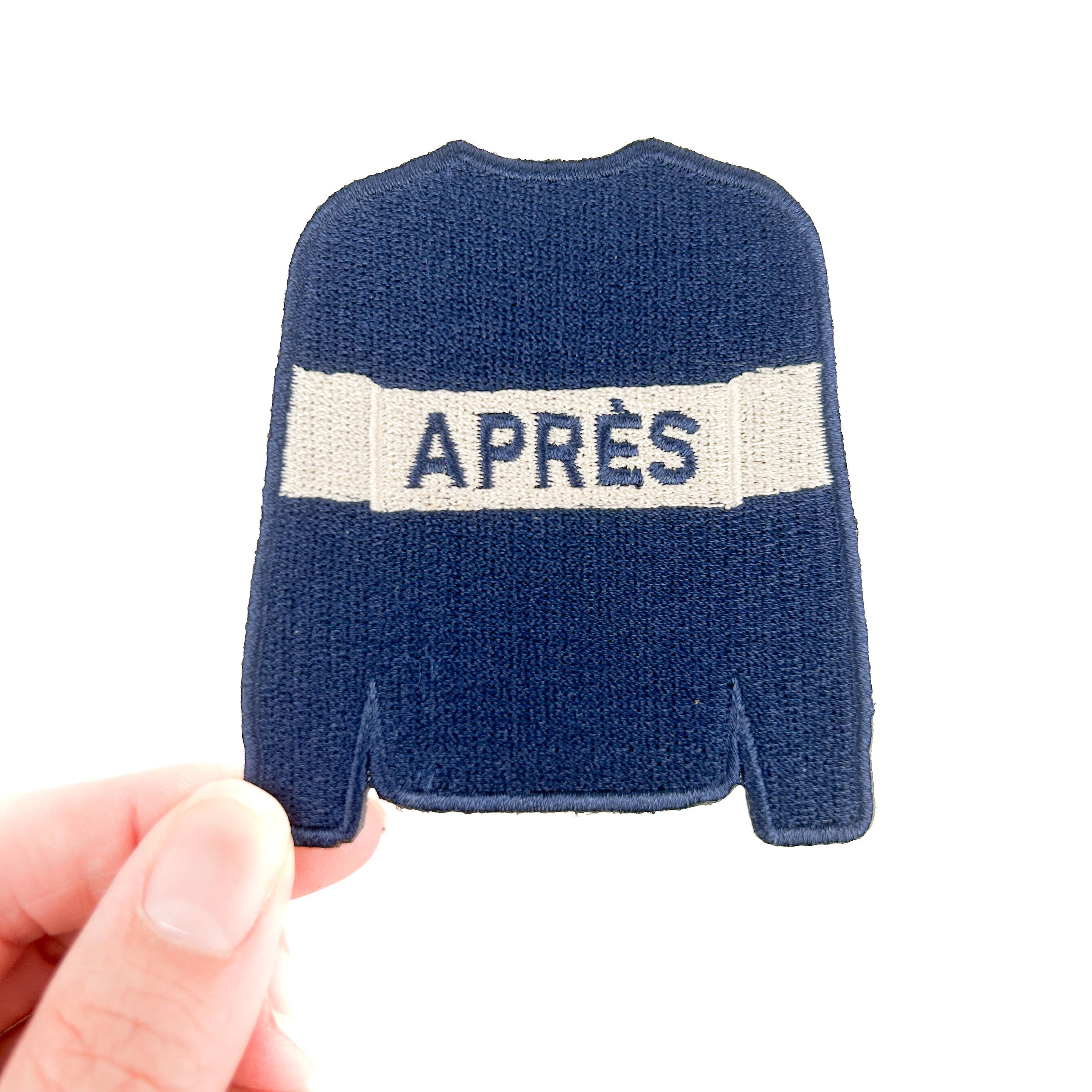 Embroidered iron on patch of a Blue sweater with white stripe saying 'APRèS' on it. 