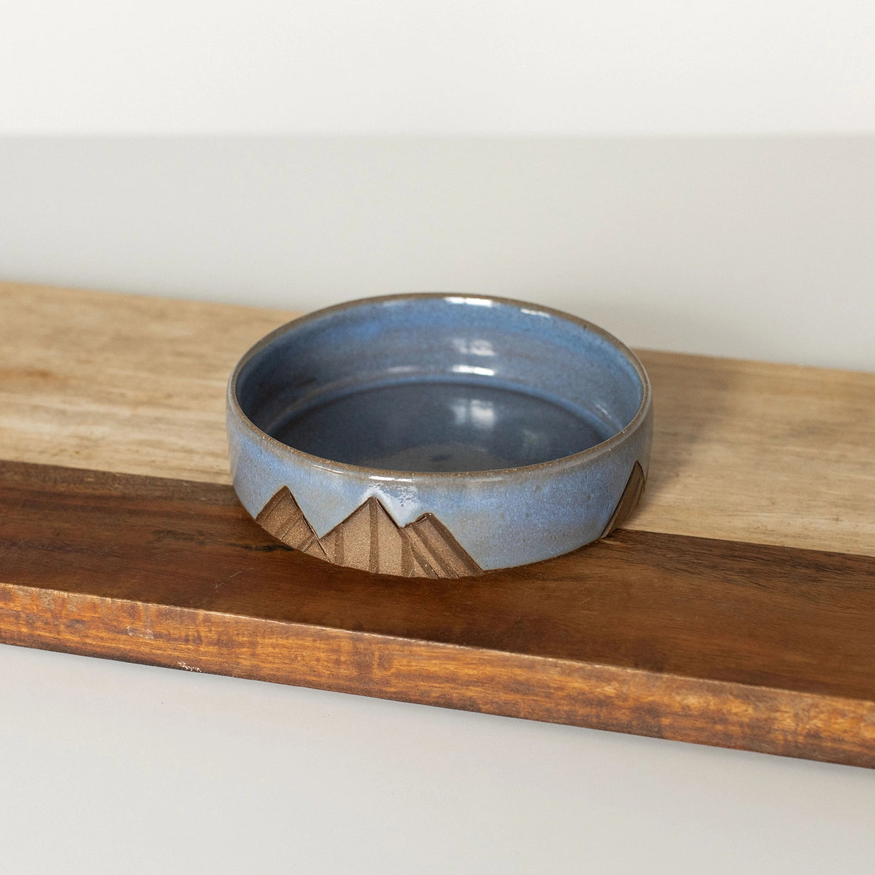 Ceramic bowl with mountain design on a wooden surface