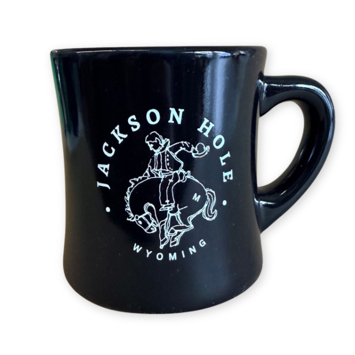 Black ceramic mug featuring a white bucking bronco design and “Jackson Hole, Wyoming” lettering.