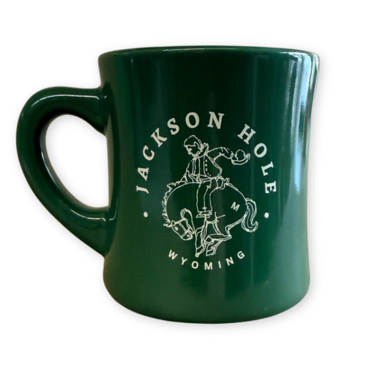 Green ceramic mug featuring a white bucking bronco design and “Jackson Hole, Wyoming” lettering.