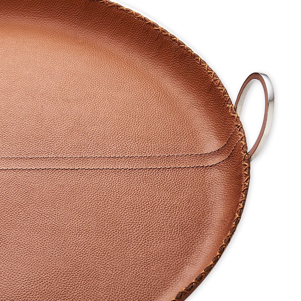 Close-up of a brown leather tray with a handle on a white background