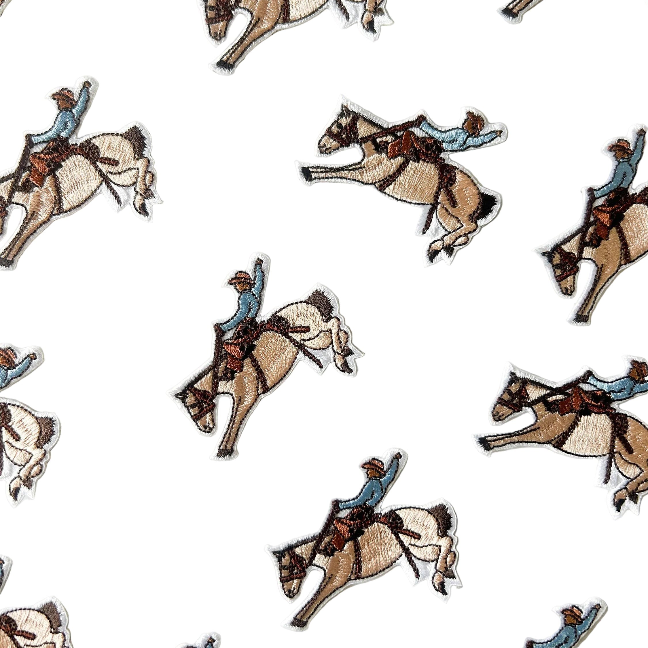 Embroidered iron on patch of a cowboy riding a bucking horse.