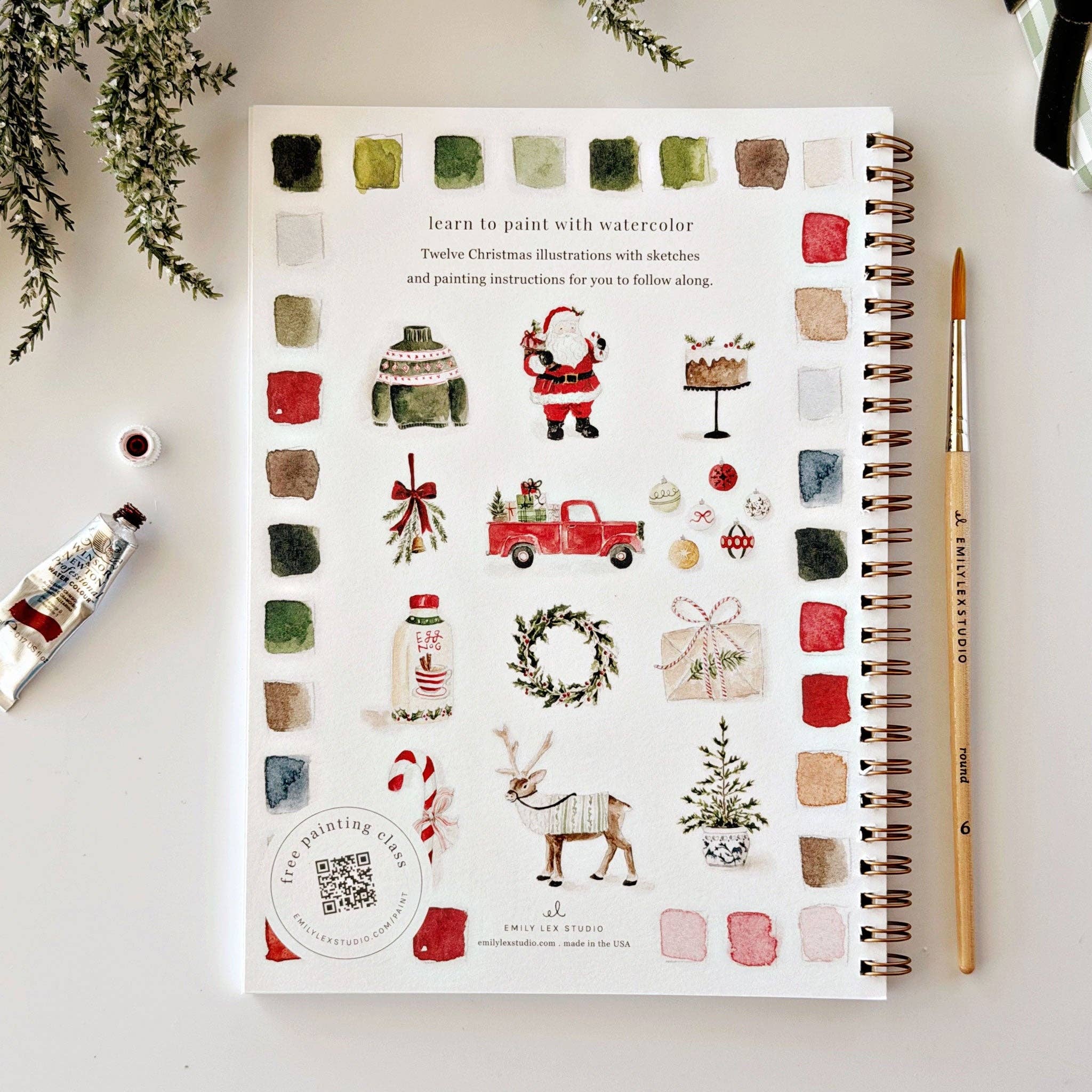 A spiral-bound watercolor painting book titled 'Learn to paint with watercolor' featuring Christmas illustrations.