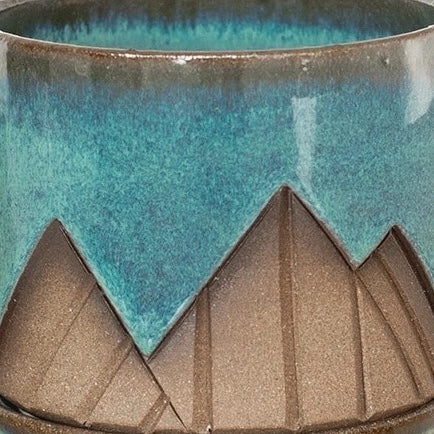 Close-up of a ceramic pot with a geometric design and two-tone color pattern.