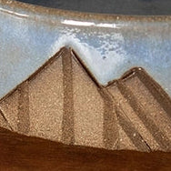 Ceramic bowl with mountain design on a wooden surface