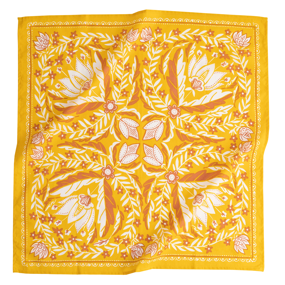 A gold-colored bandana with a floral pattern in cream flowers, folded to show the design.