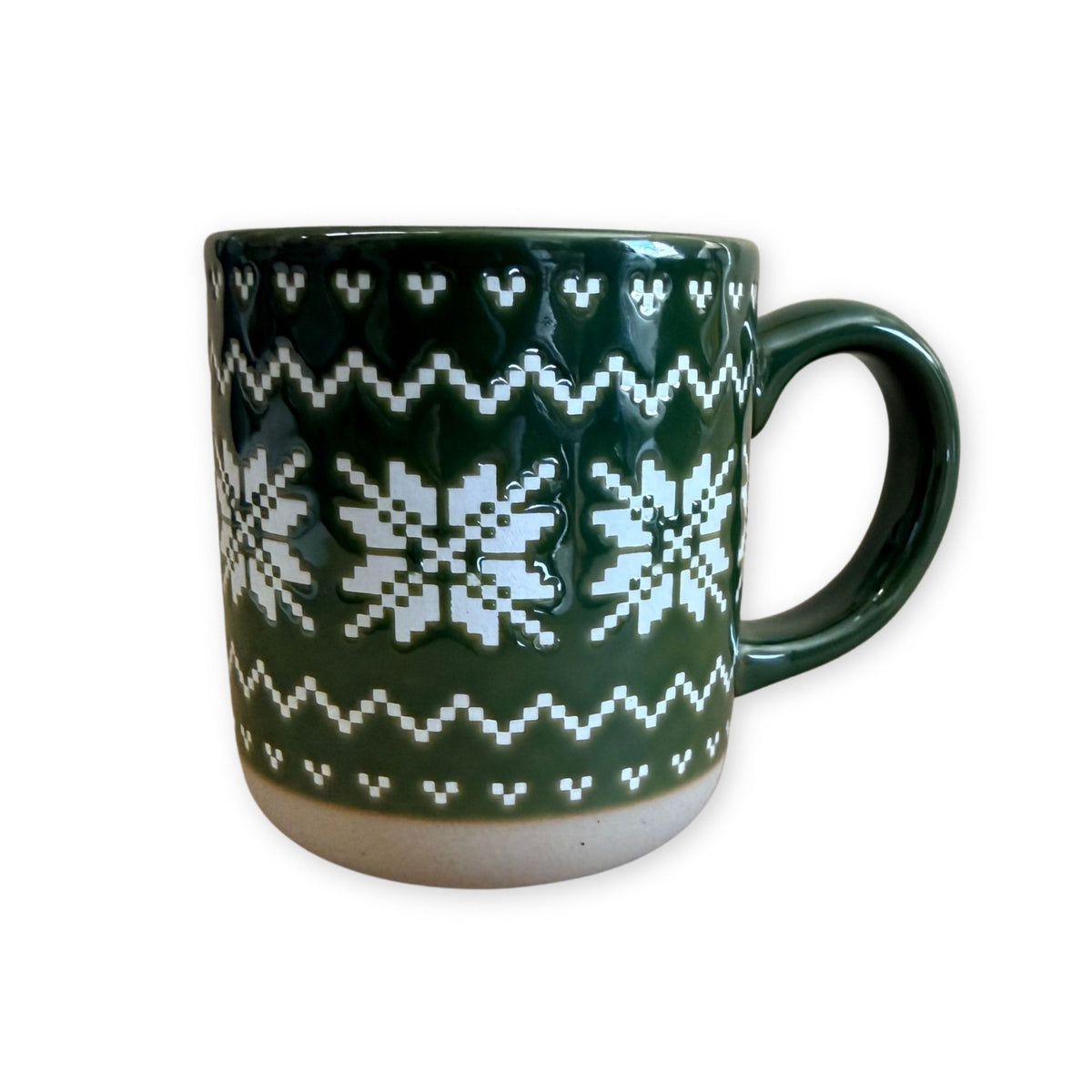 This cozy stoneware mug wraps your morning coffee, tea, or hot cocoa in an embossed Fair Isle sweater pattern and a pretty green glaze.