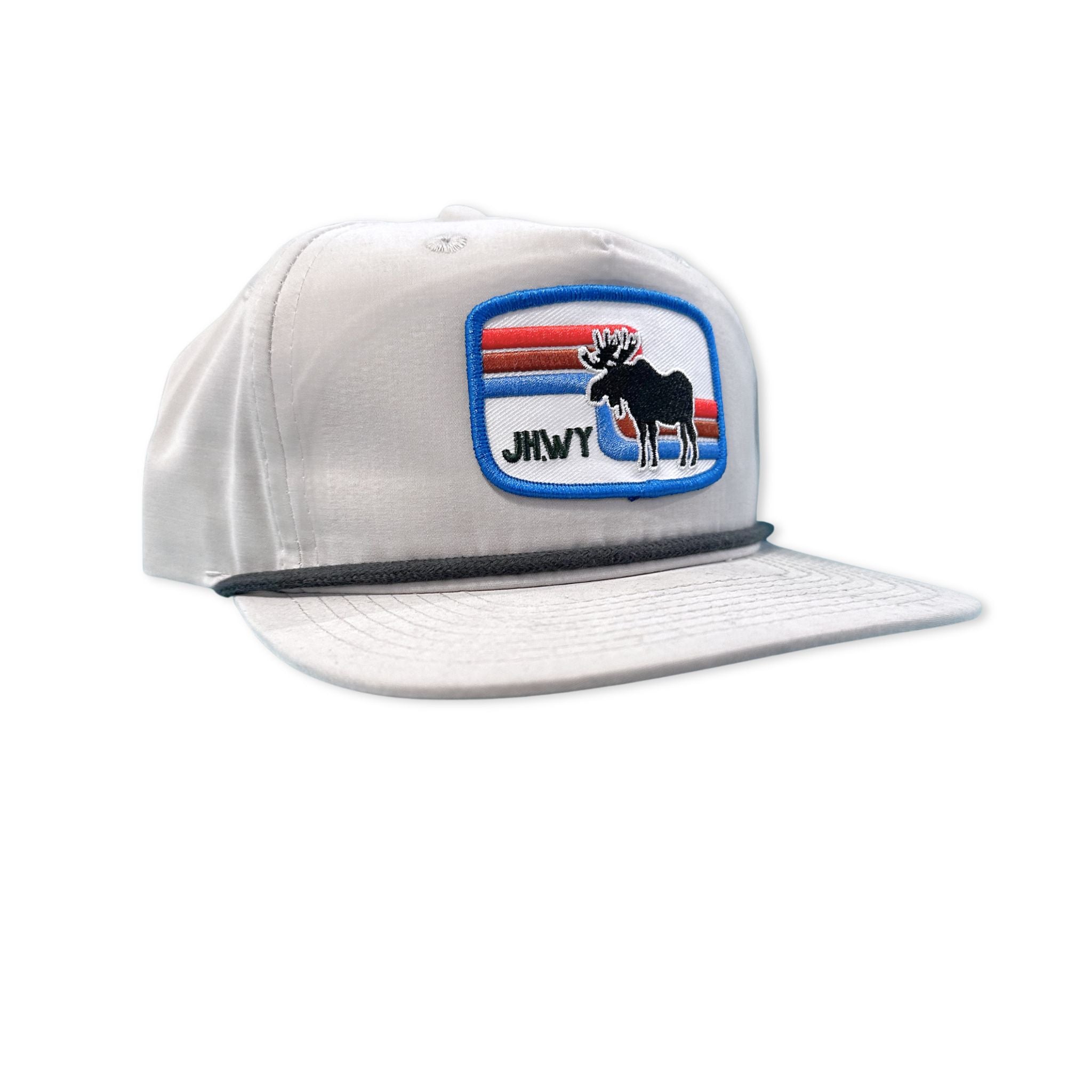 A grey flat bill hat featuring a retro looking patch that has a moose, retro colored lines, and text stating JH.WY 
