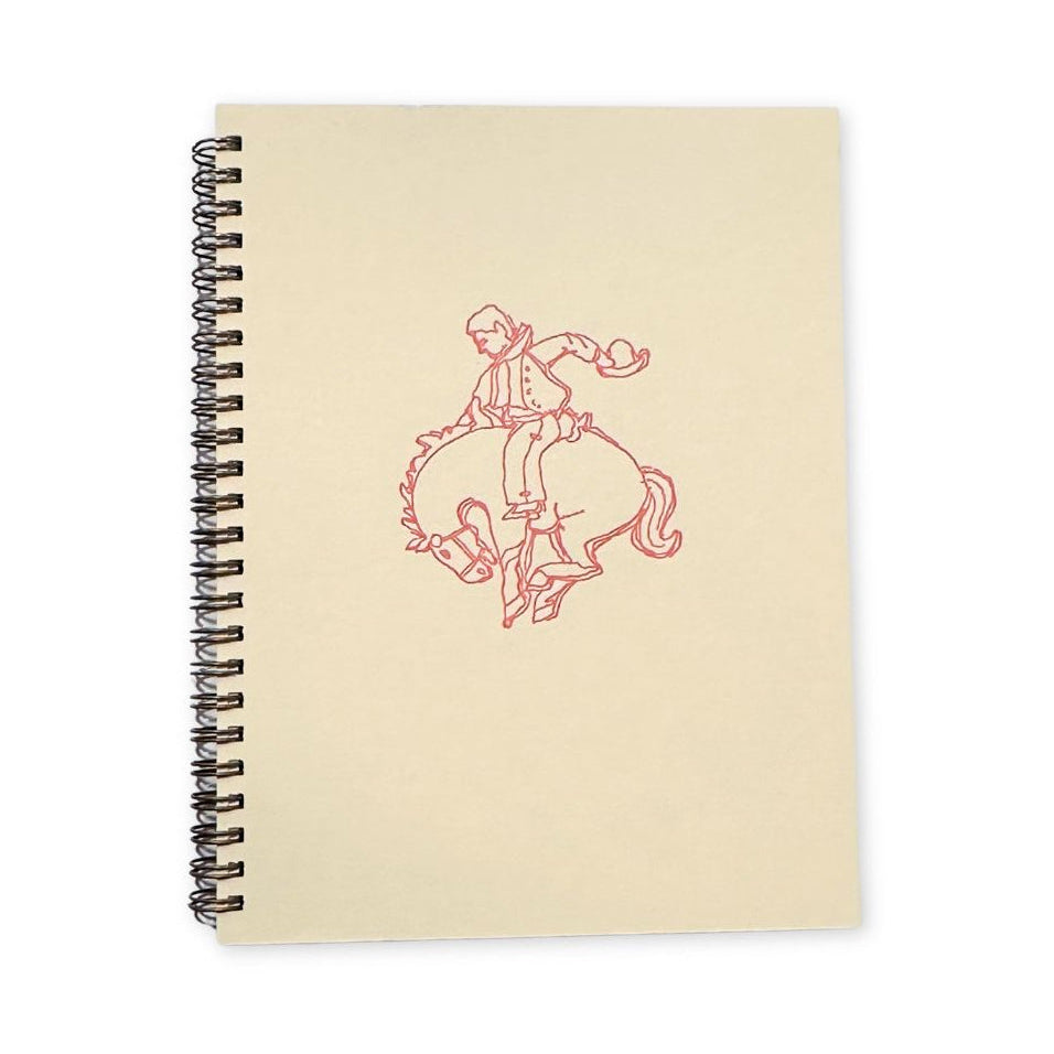 A beige notebook with the iconic bucking bronco illustration in a light pink. 