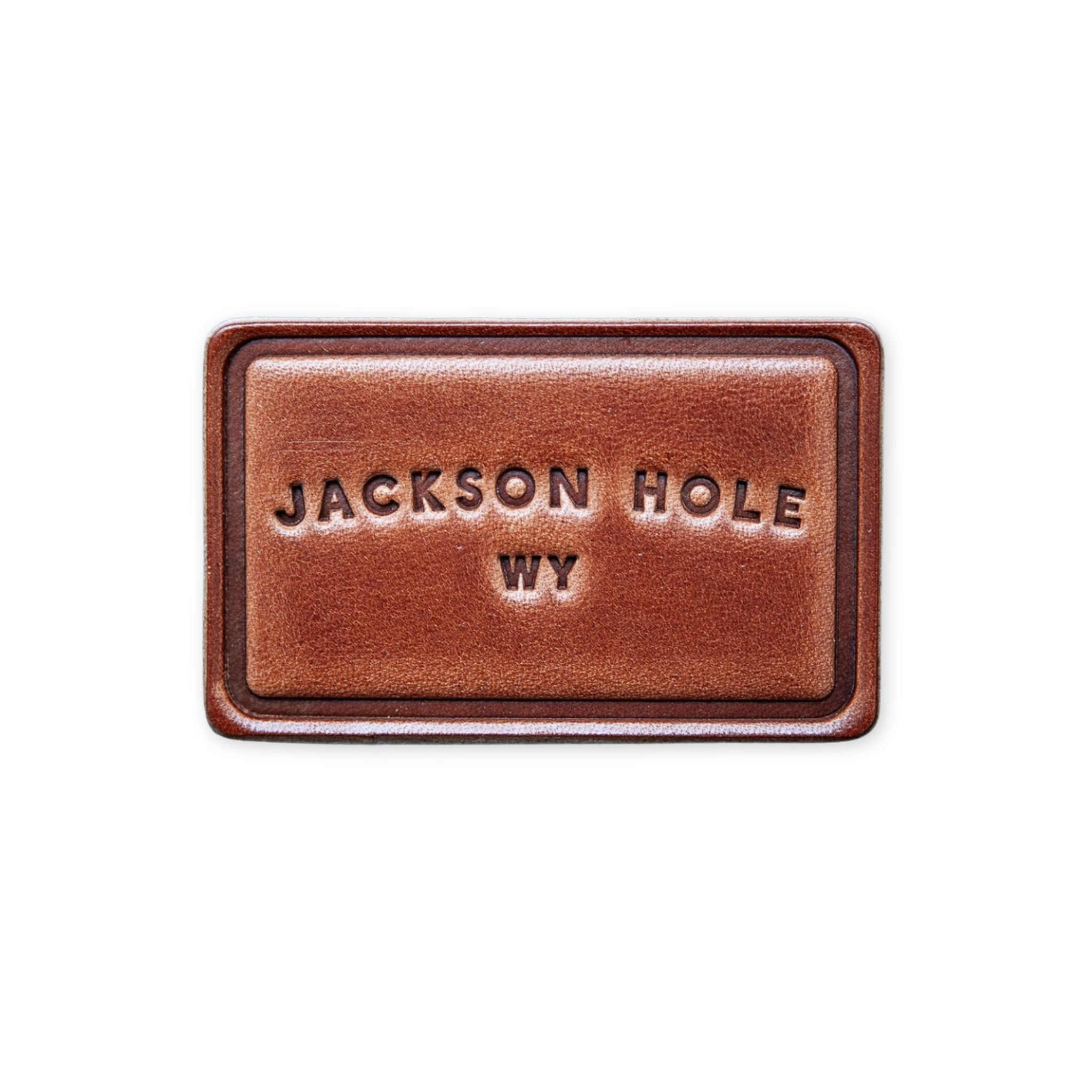 Brown leather magnet with "Jackson Hole WY" text in arc design.