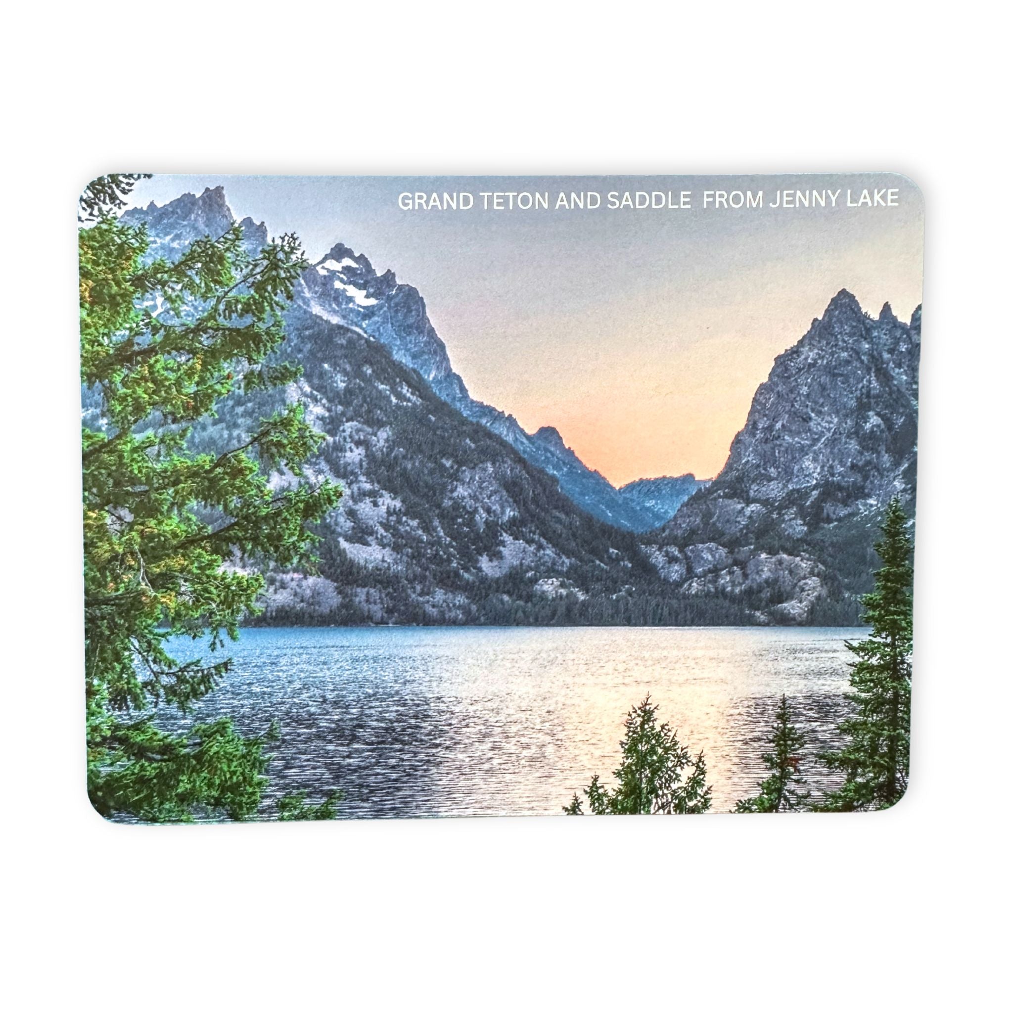 Postcard showing Scenic view of Grand Teton and Saddle from Jenny Lake with trees and water.