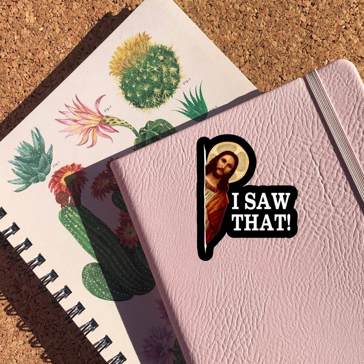 Jesus I Saw That Sticker on a pink notebook cover with a cactus print notebook beneath, glossy vinyl by Sticker Horse