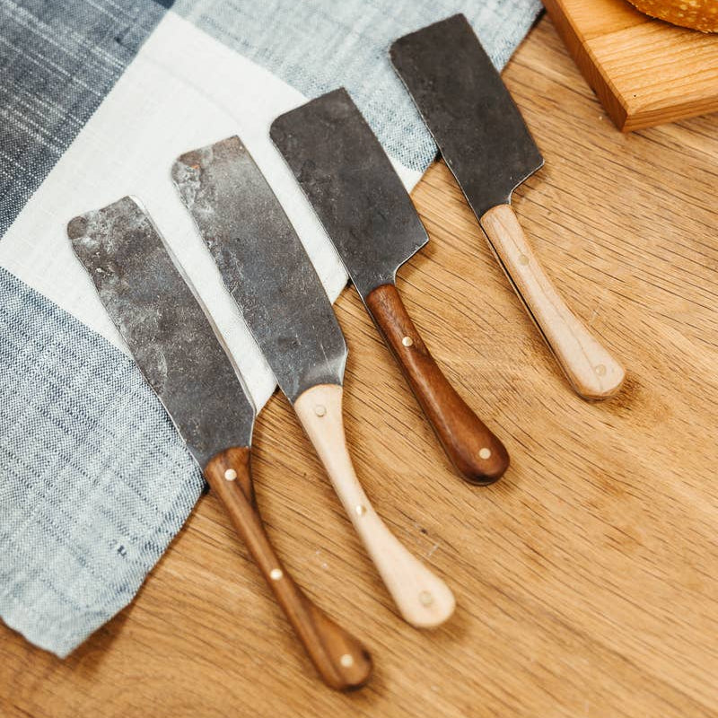Set of bread knives with wooden handles on a wooden surface