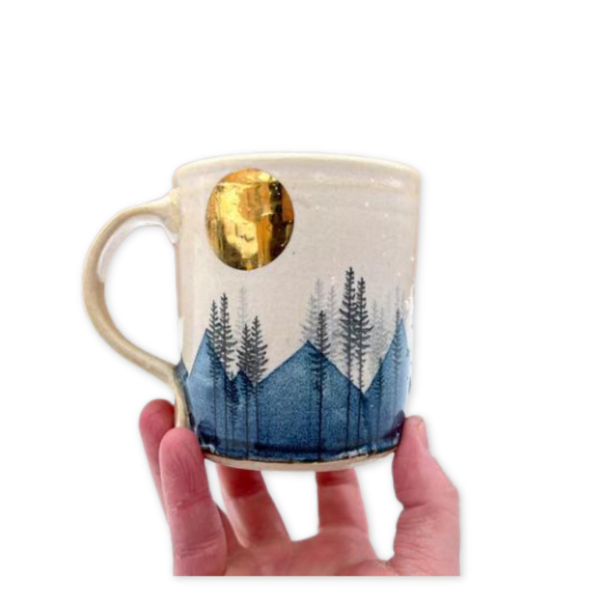 ceramic mug with a gold moon and a blue mountain range and pine tree design