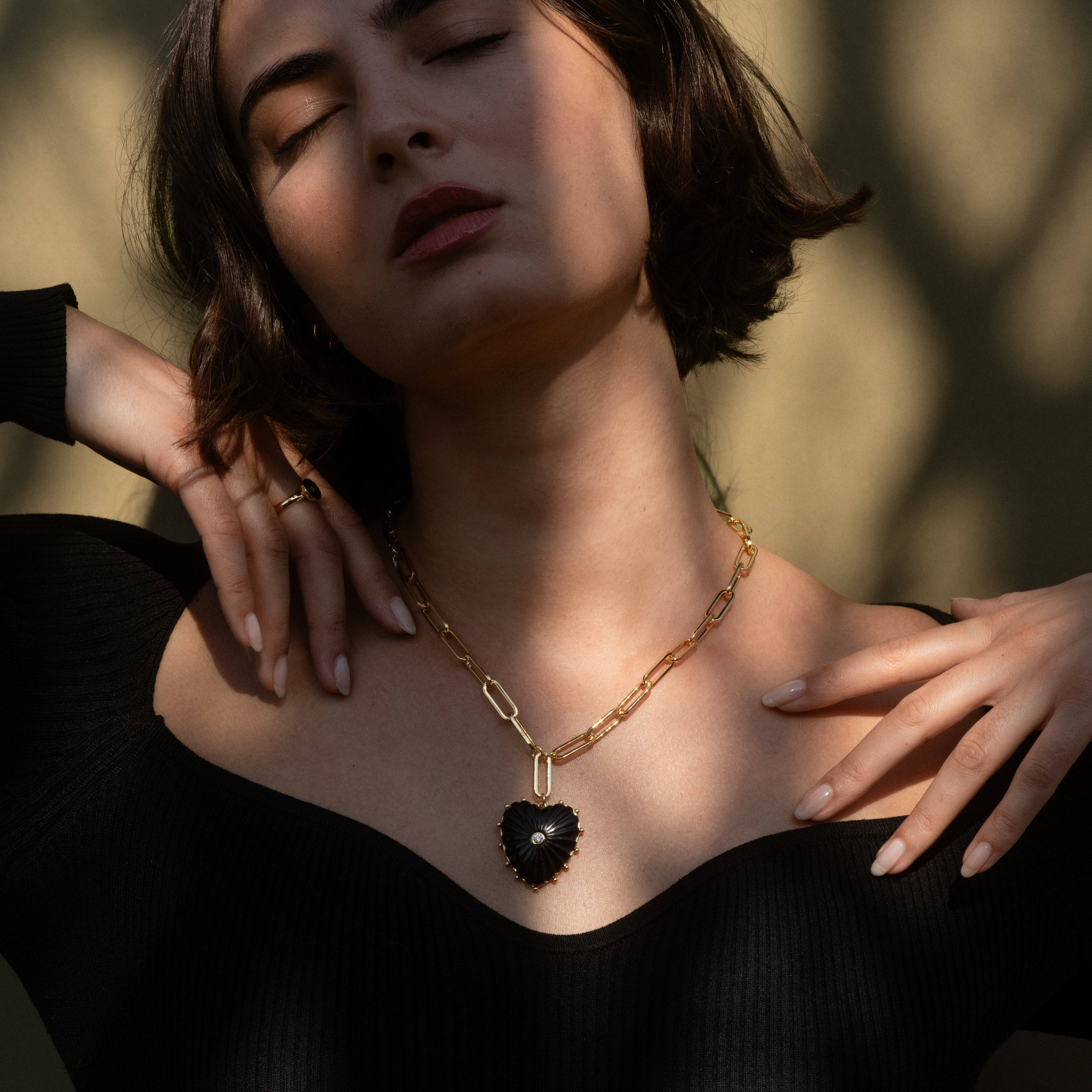 Women wearing heart necklace.