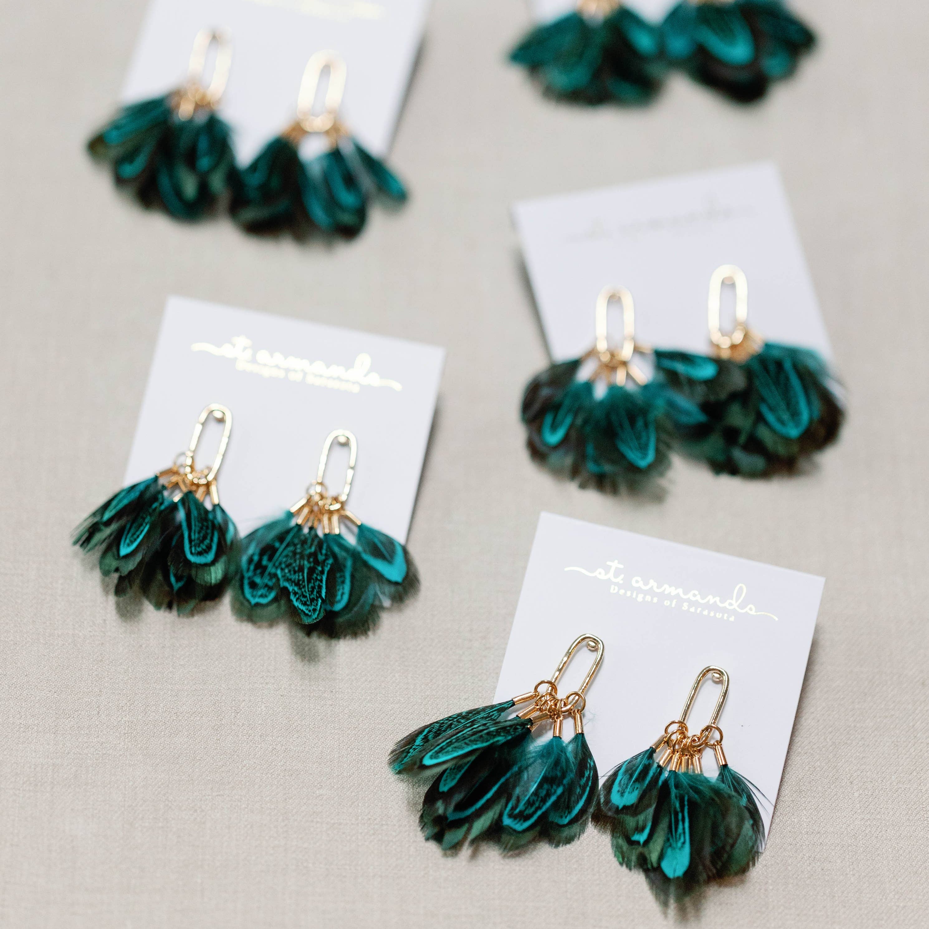 Green peacock feather earrings with a gold dangle.