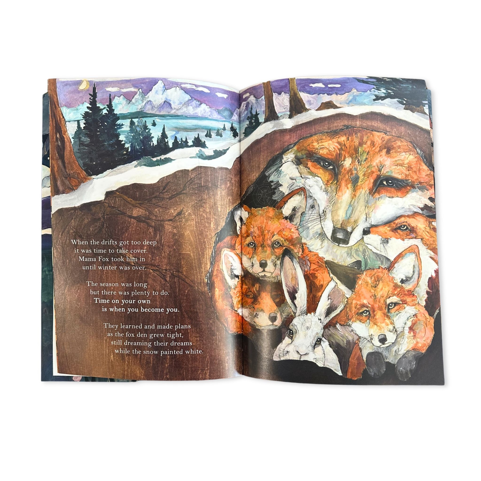Open book with illustrations of foxes and a snowy landscape